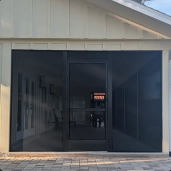 Dark screen room built onto a white board-and-batten house