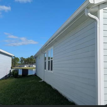 New seamless gutter run along the side of a house against a blue sky